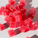 Kush Queen Strawberry THC and CBD gummies on white surface.